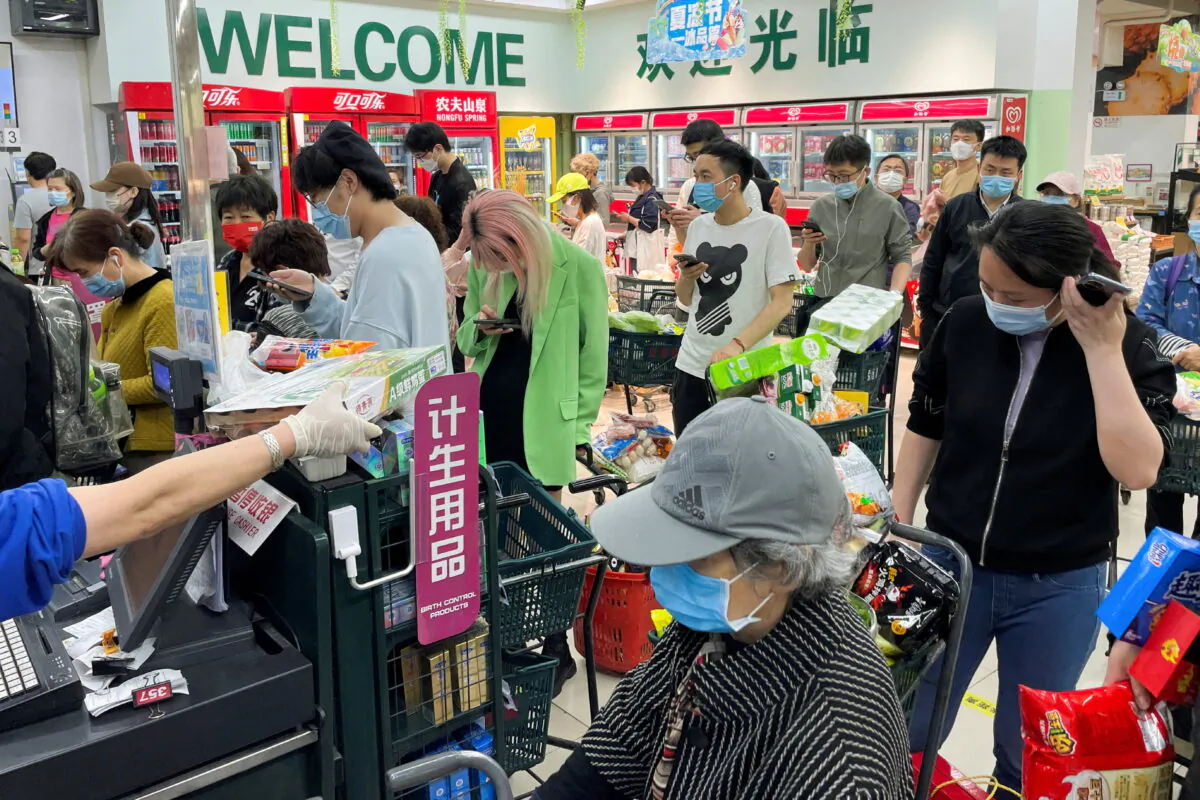 People wearing protective masks wait in lines to pay for their products at a supermarket following the COVID-19 outbreak, in Chaoyang district of Beijing, on Apr. 24, 2022. (Carlos Garcia Rawlins/Reuters)