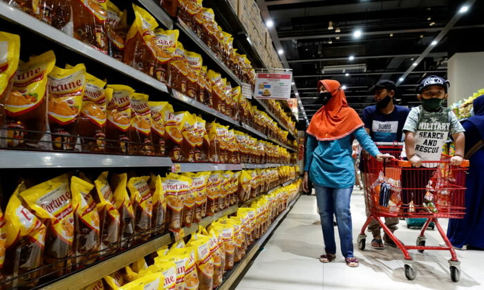 People shop for cooking oil made from oil palms at a supermarket in Jakarta, Indonesia, on March 27, 2022. (Willy Kurniawan/Reuters)
