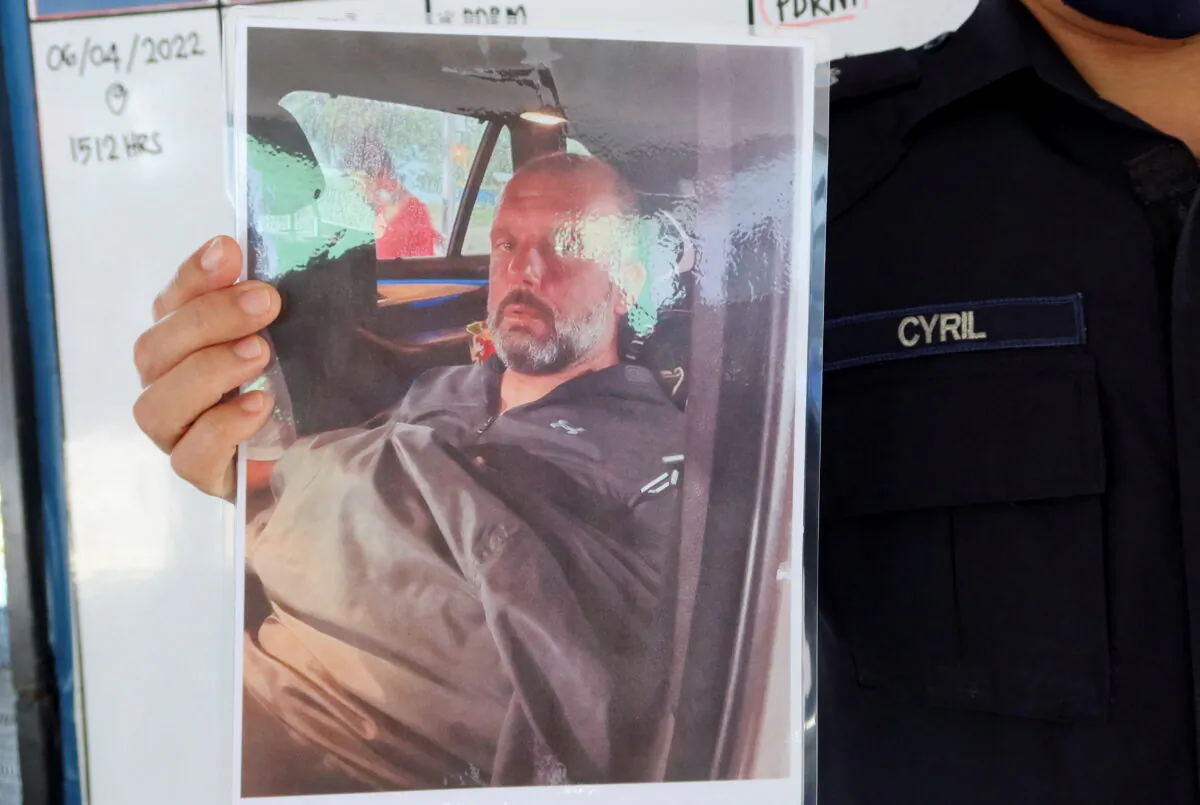 Mersing district police chief Cyril Edward shows a picture of British man Adrian Peter Chesters, who was found safe after drifting at sea for two and a half days, during a press conference at Mersing, Johor, Malaysia, on April 9, 2022. (Ebrahim Harris/Reuters)