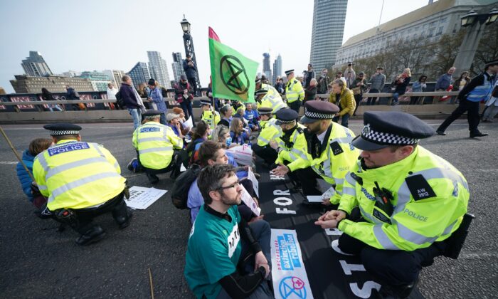 Police talk to protesters taking part in a demonstration on Lambeth Bridge in central London, on April 10, 2022. (Yui Mok/PA)