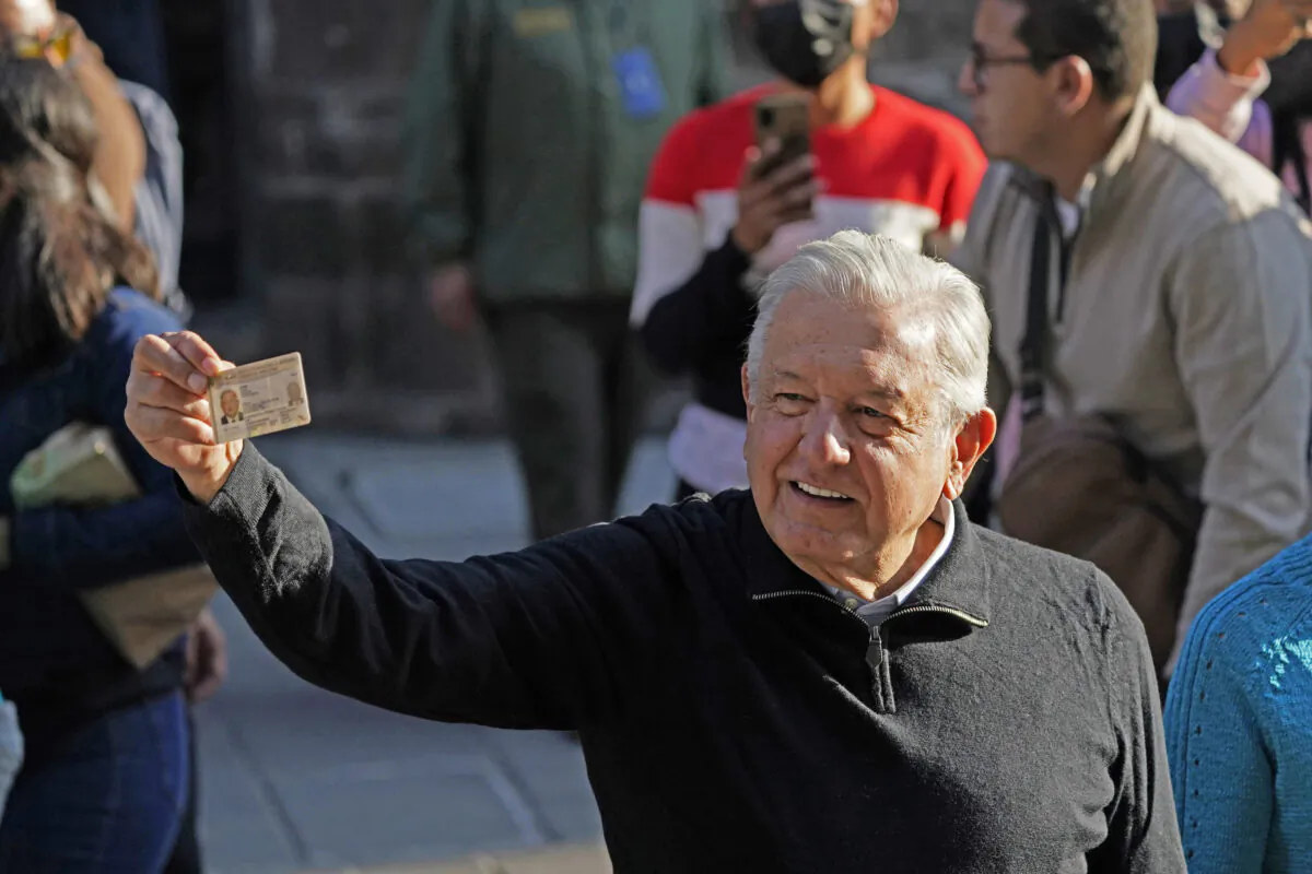 Mexico's President Andres Manuel López Obrador shows his identification card after voting in a national referendum on whether he should end his six-year term barely midway through or continue to the end, outside his polling station in Mexico City, on April 10, 2022. (Eduardo Verdugo/AP Photo)