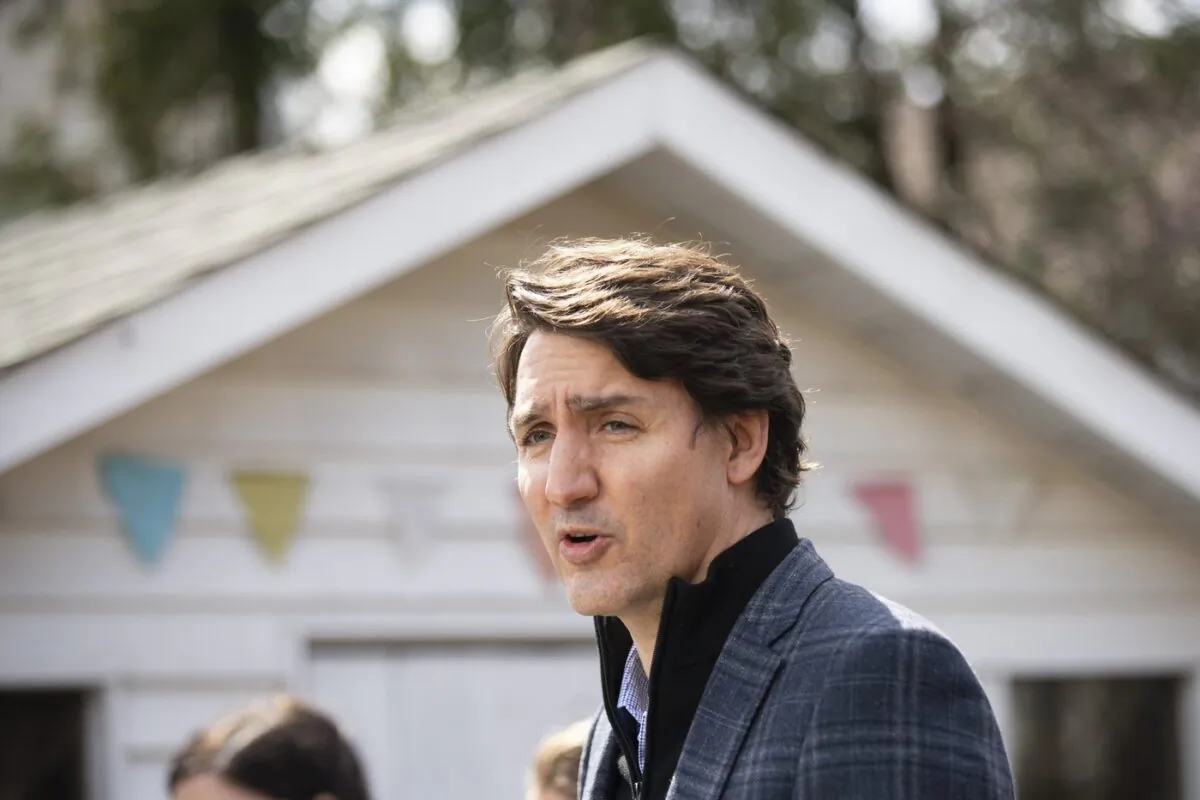 Prime Minister Justin Trudeau speaks about Budget 2022 highlights on housing investments from a podium in a backyard in Hamilton, April 8, 2022. (The Canadian Press/Peter Power)