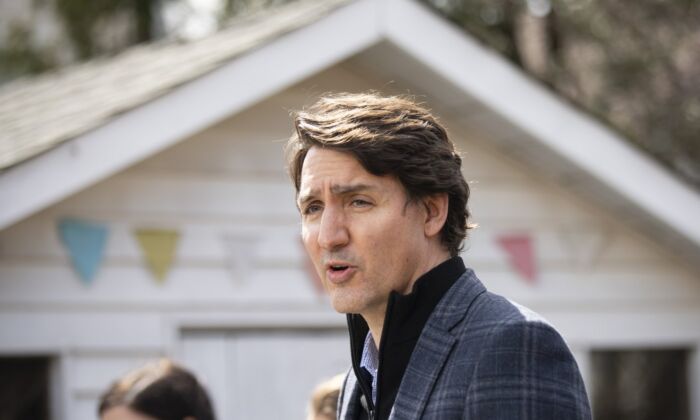 Prime Minister Justin Trudeau speaks about Budget 2022 highlights on housing investments from a podium in a backyard in Hamilton on April 8, 2022. (Peter Power/The Canadian Press)