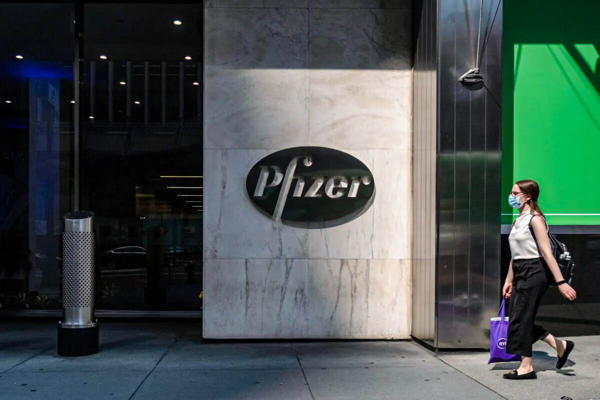 A pedestrian walks by Pfizer's New York headquarters in a file photograph. (Jeenah Moon/Getty Images)