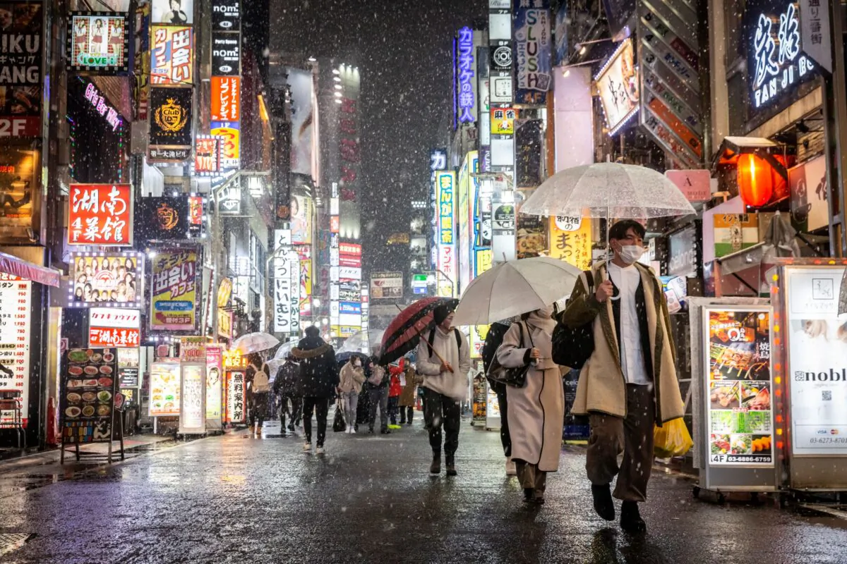 People walk through Kabukicho area during heavy snow in Tokyo on Feb. 10, 2022. (Yamazaki/Getty Images)