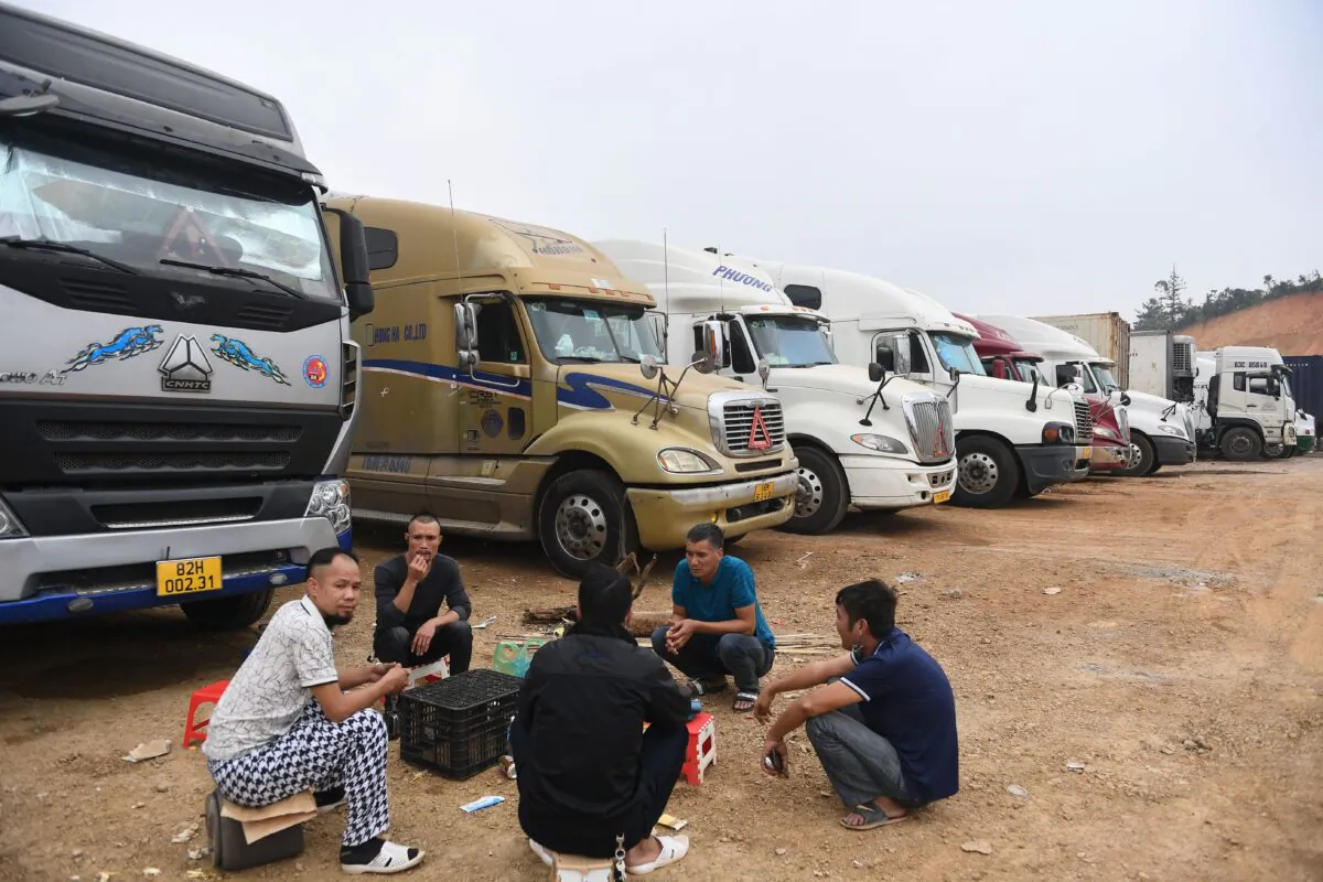 Truck drivers gather at a makeshift parking lot where Vietnamese container trucks are waiting to cross the Vietnam-China border in Lang Son Province on Jan. 7, 2022, as thousands of trucks carrying fruit remained stuck at the border while China tightened its border policies. (STR/AFP via Getty Images)