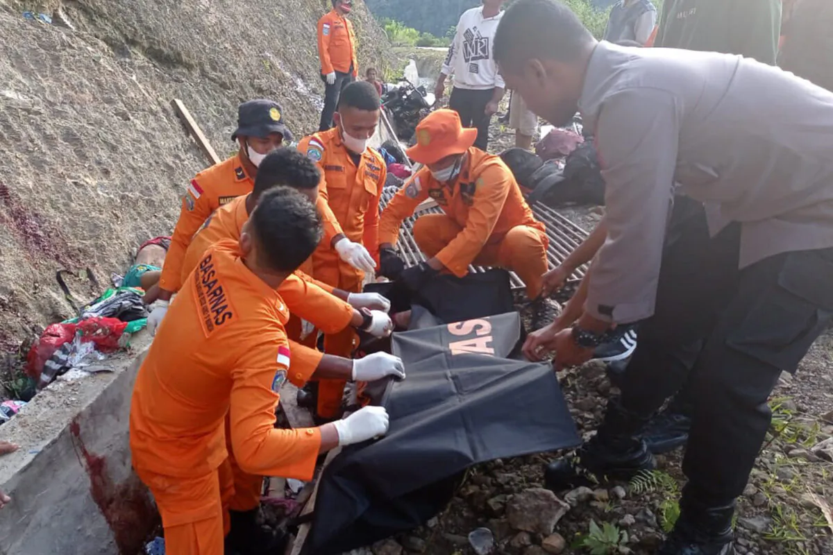 Rescuers put the body of a victim into a body bag after a truck accident in Manokwari, West Papua, Indonesia, on April 13, 2022. (BASARNAS via AP)