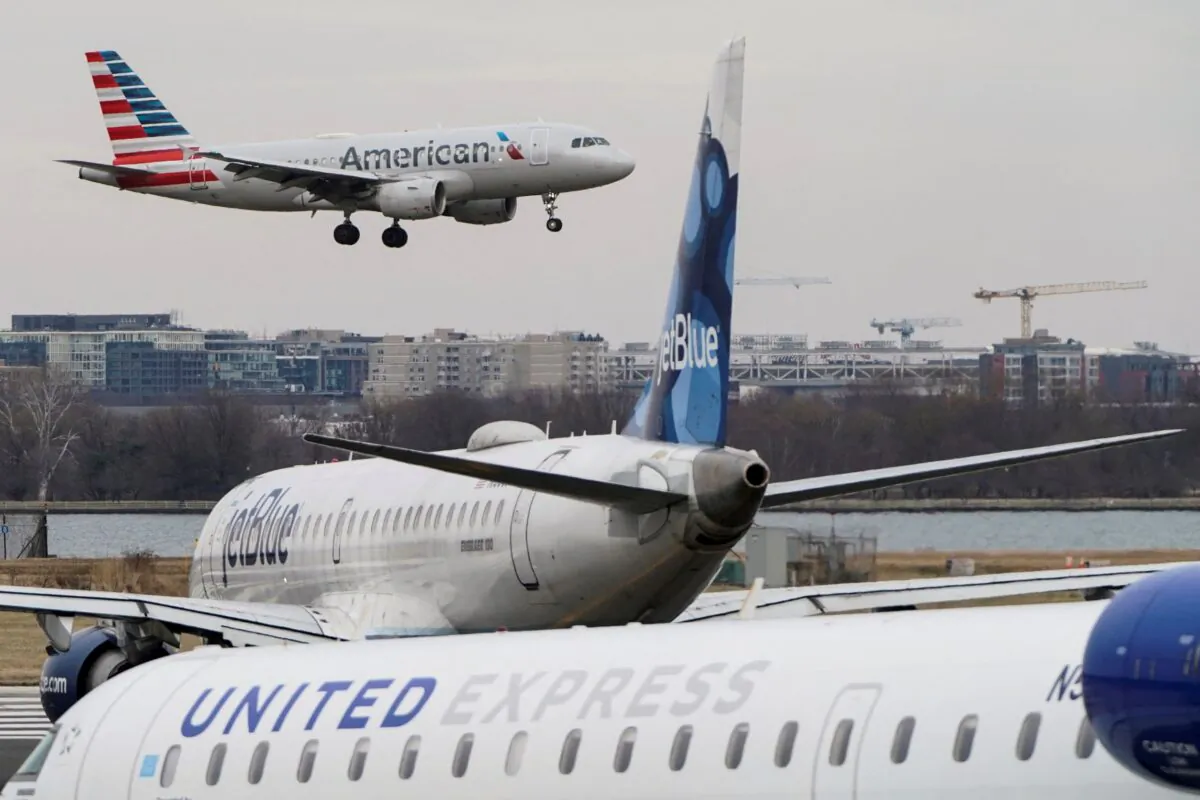 An American Airlines aircraft flies past JetBlue and United Express aircraft as it lands at Reagan National Airport in Arlington, Virginia, United States, on Jan. 24, 2022. (Joshua Roberts/Reuters)