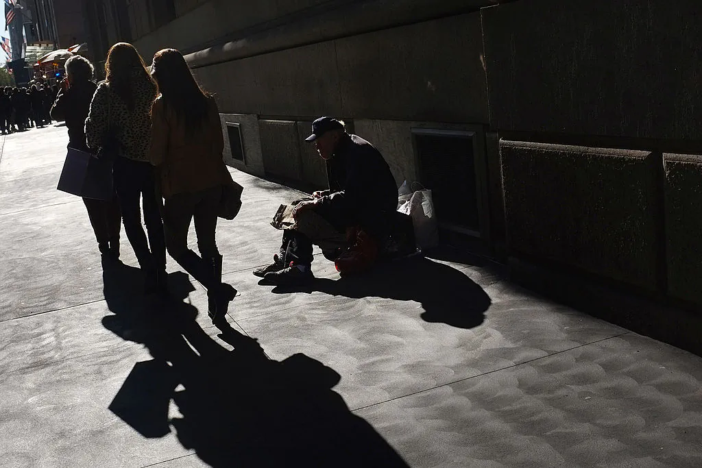 Women walk by a panhandler along Madison Avenue, one of Manhattan's premier shopping and residential streets in this 2011 file photo taken in New York.  (Spencer Platt/Getty Images)