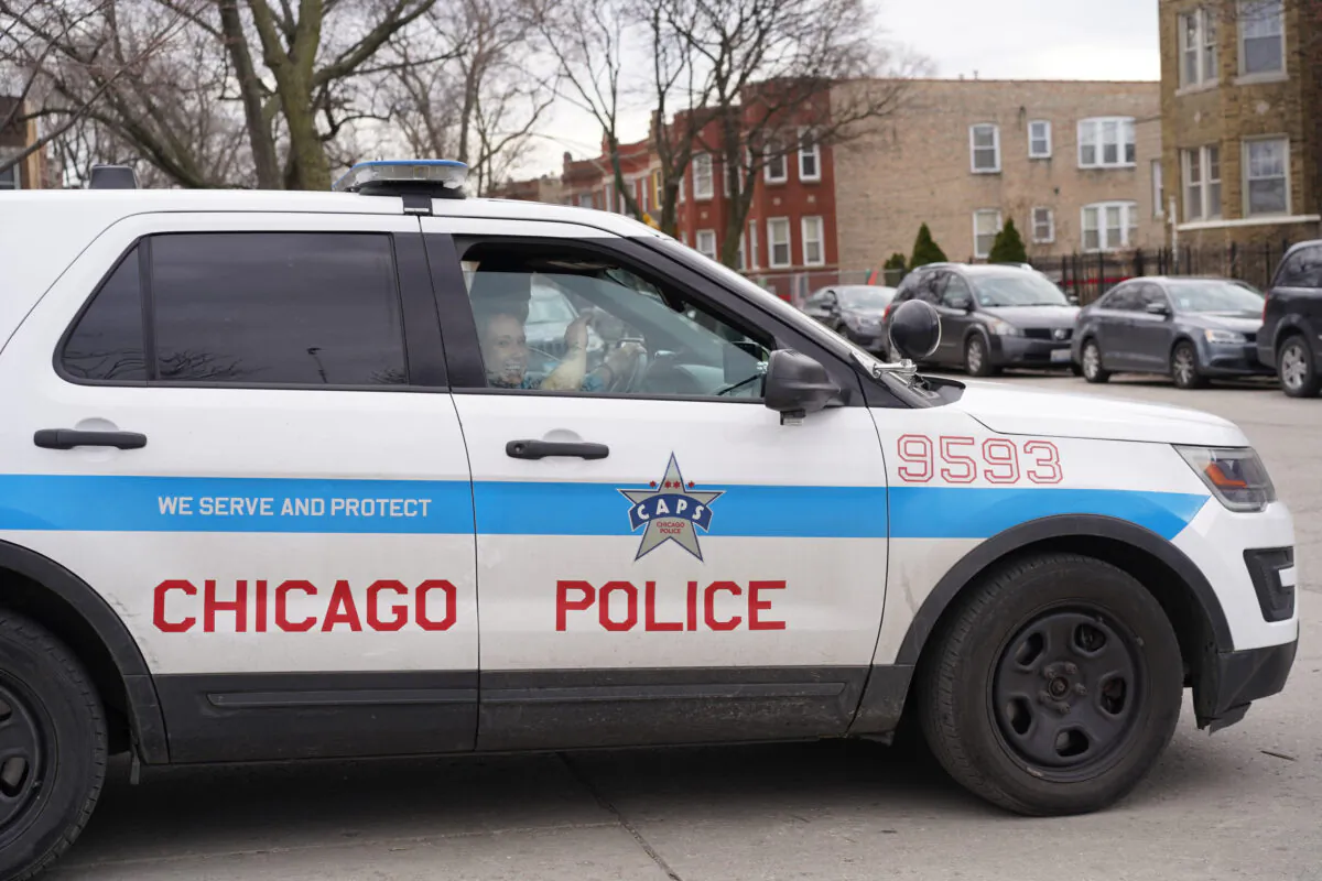 Chicago police officers patrol near a known open air drug market in the Humboldt Park neighborhood on the West Side of Chicago on April 11, 2022. (Cara Ding/The Epoch Times)