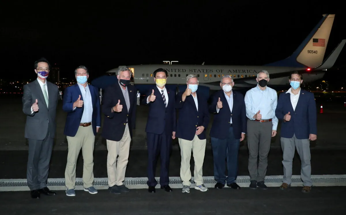 Taiwan Foreign Minister Joseph Wu (4th L) pose for a family photo with members of the U.S. delegation as they arrive at Taipei Songshan airport in Taipei, Taiwan, on April 14, 2022. (Taiwan Ministry of Foreign Affairs/Handout via Reuters)