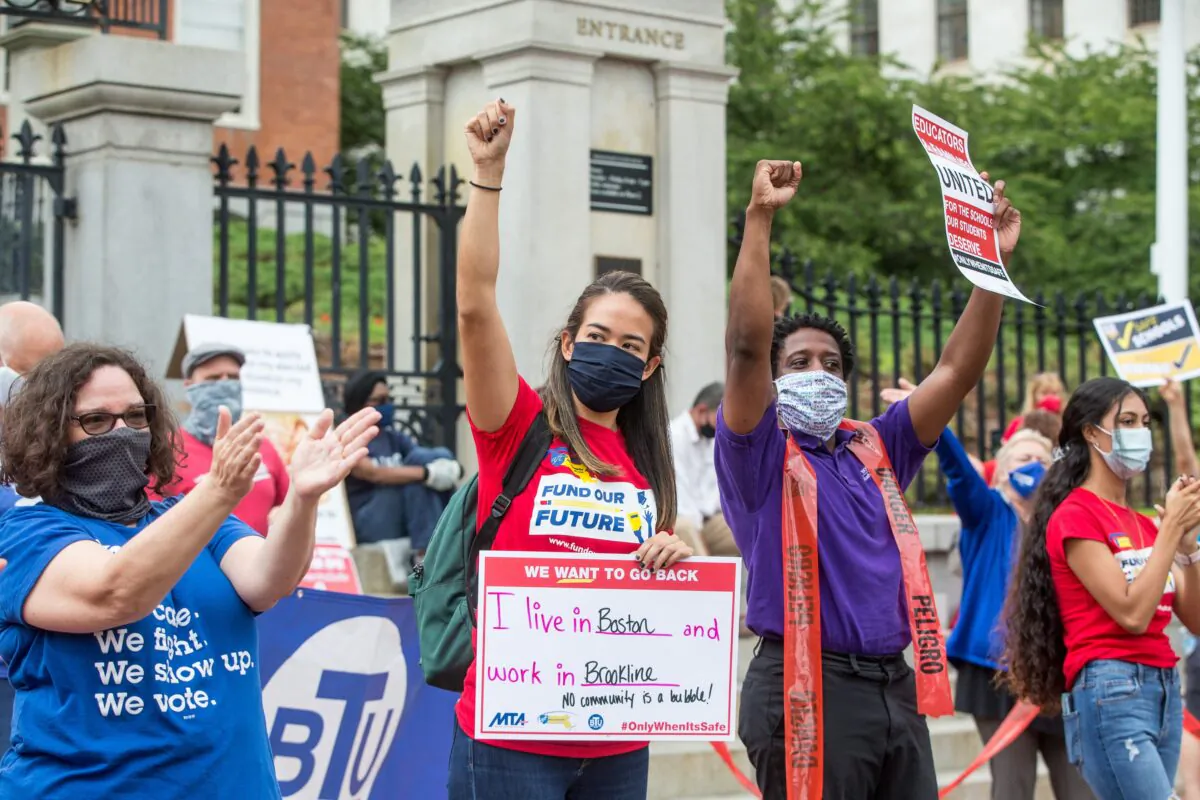People who are part of standout protest organized by the American Federation of Teachers chant, hold signs, and raise their fists outside of the Massachusetts State House in Boston, Mass., on Aug. 19, 2020. (Scott Eisen/Getty Images)