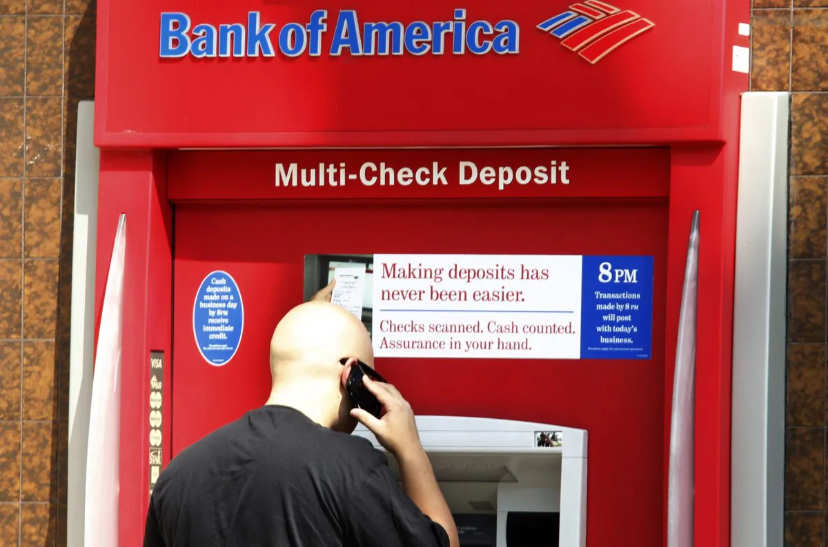 A customer stands at a Bank of America office's ATM machine in Burbank, Calif., on Aug. 19, 2011. (Fred Prouser/Reuters)