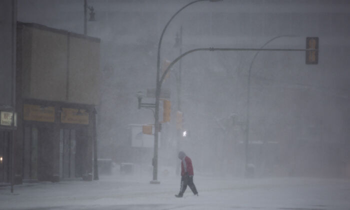 A pedestrian walks through the downtown area during a snowstorm in Saskatoon on November 8, 2020. (The Canadian Press/Kayle Neis)