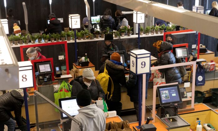People pay for their purchases at a supermarket in New York, on March 28, 2022. (Andrew Kelly/Reuters)