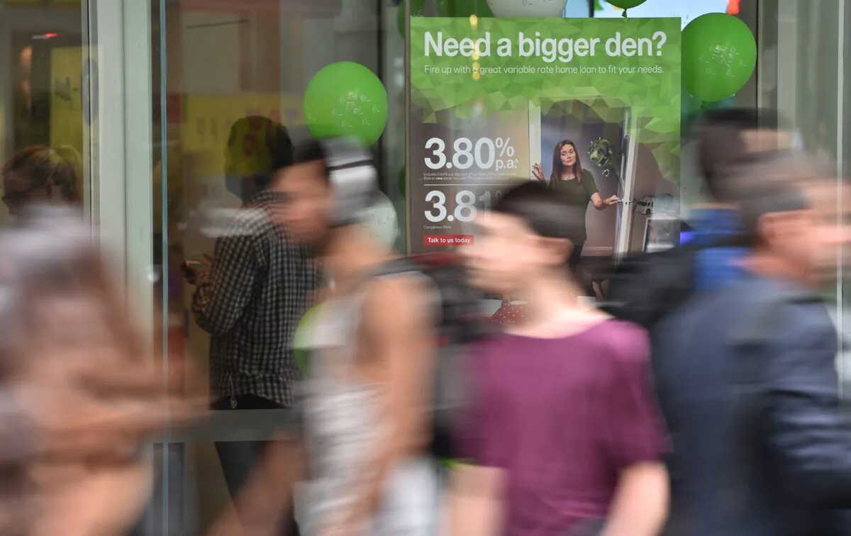 Pedestrians pass a bank advertising interest rates on mortgages in Sydney, Australia, on Oct. 3, 2017. (Peter Parks/AFP via Getty Images)