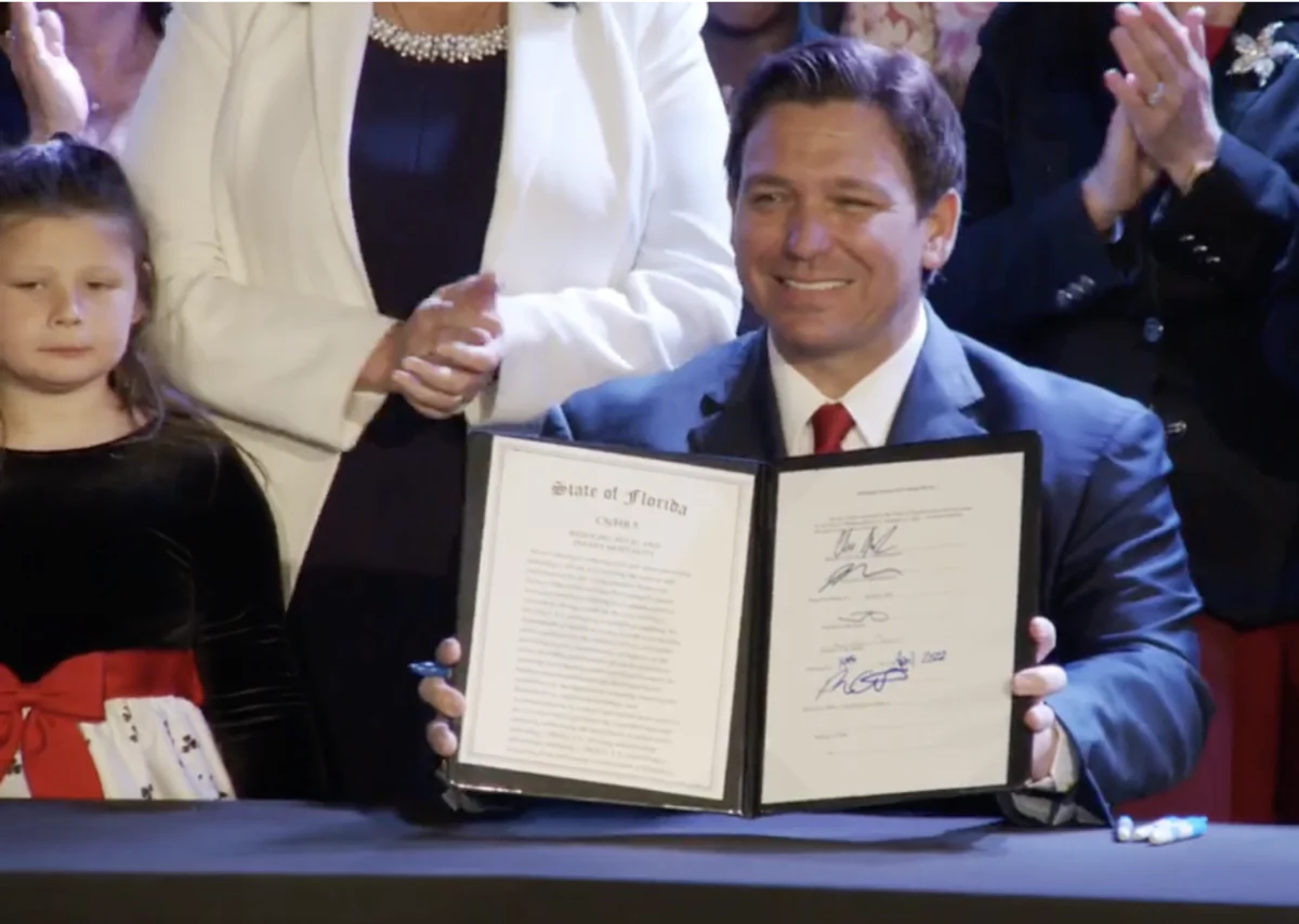 Florida Gov. Ron DeSantis displays the signed bill that he says increases protections for unborn children. (Screenshot, Gov. Ron DeSantis Facebook Page)