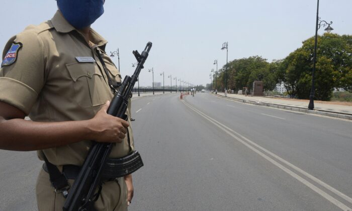 A policeman stands guard on a deserted street in Hyderabad on May 13, 2021. (Noah Seelam/AFP via Getty Images)