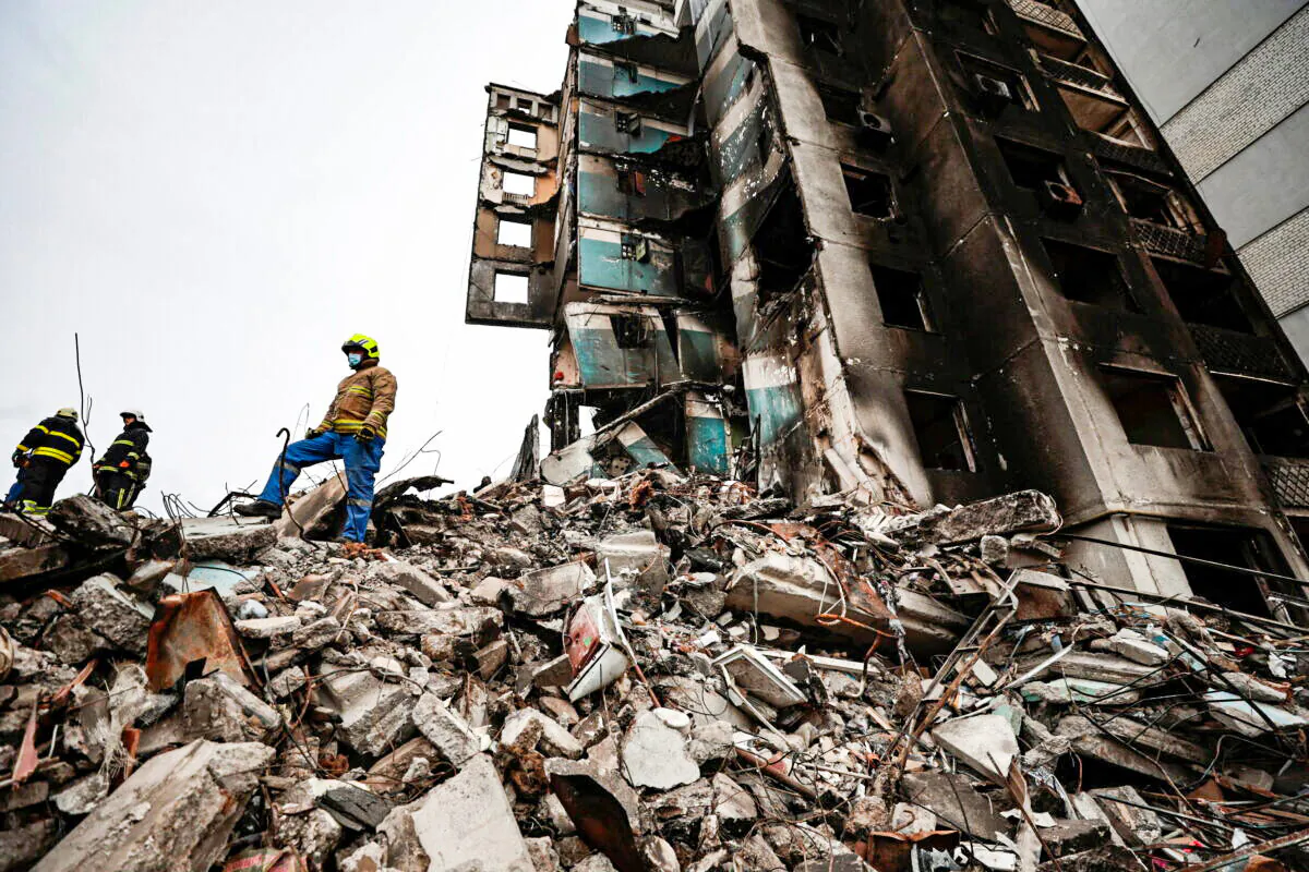 A rescuer stands on the rubble of a building destroyed by Russian shelling, as they start searching for bodies, in Borodyanka, Kyiv region, Ukraine, on April 10, 2022. (Zohra Bensemra/Reuters)