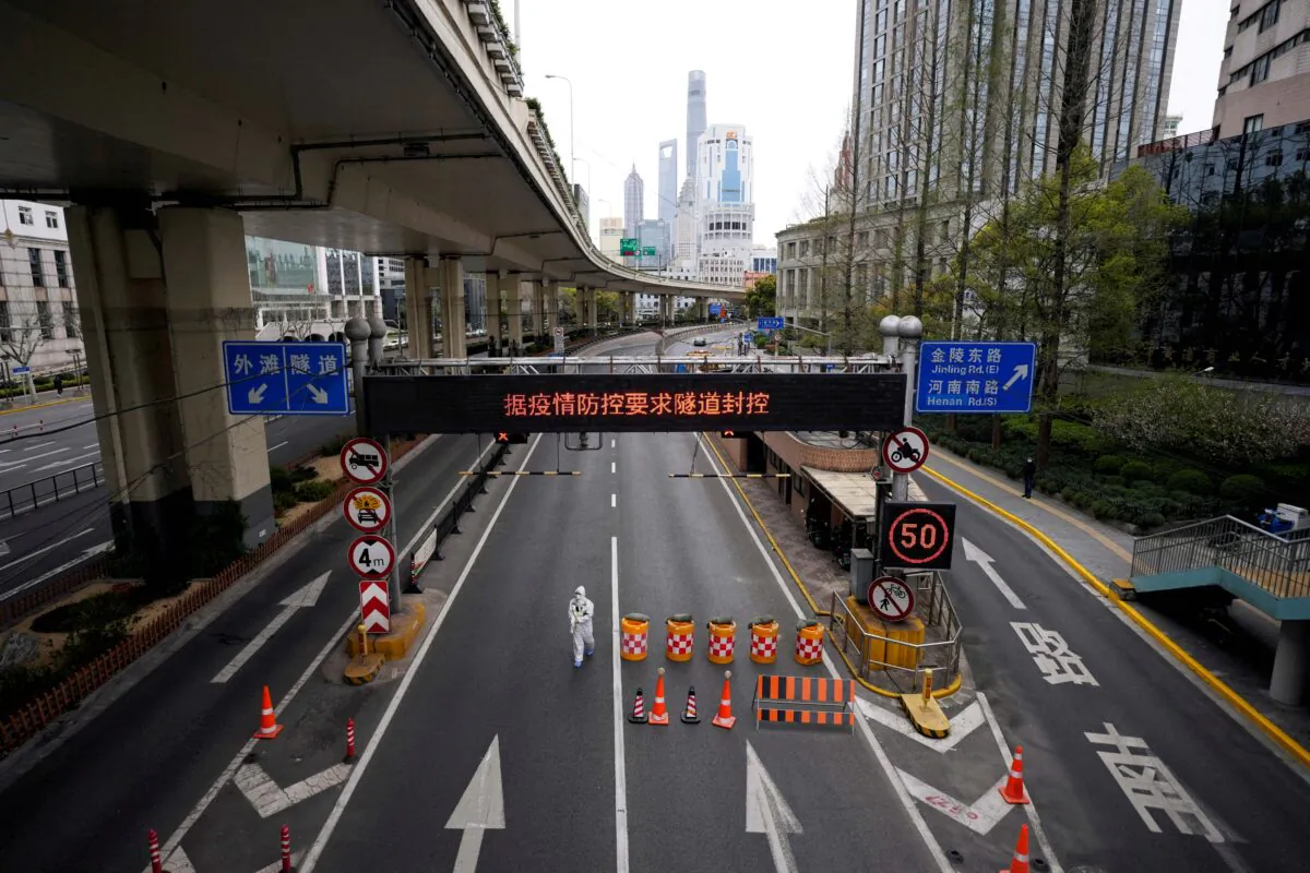 A worker in a protective suit walks at an entrance to a tunnel leading to the Pudong area across the Huangpu river, after restrictions on highway traffic amid the lockdown in Shanghai on March 28, 2022. (Aly Song/Reuters)