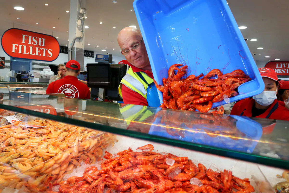 Tony Tsiklas refills a prawn display at Claudio's Seafood at the Sydney Fish Market ahead of Easter long weekend celebrations in Sydney, Australia, on April 14, 2022. (Lisa Maree Williams/Getty Images)