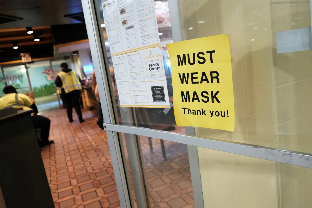 A sign on a door asks people to wear masks in downtown in Philadelphia on April 15, 2022. (Spencer Platt/Getty Images)