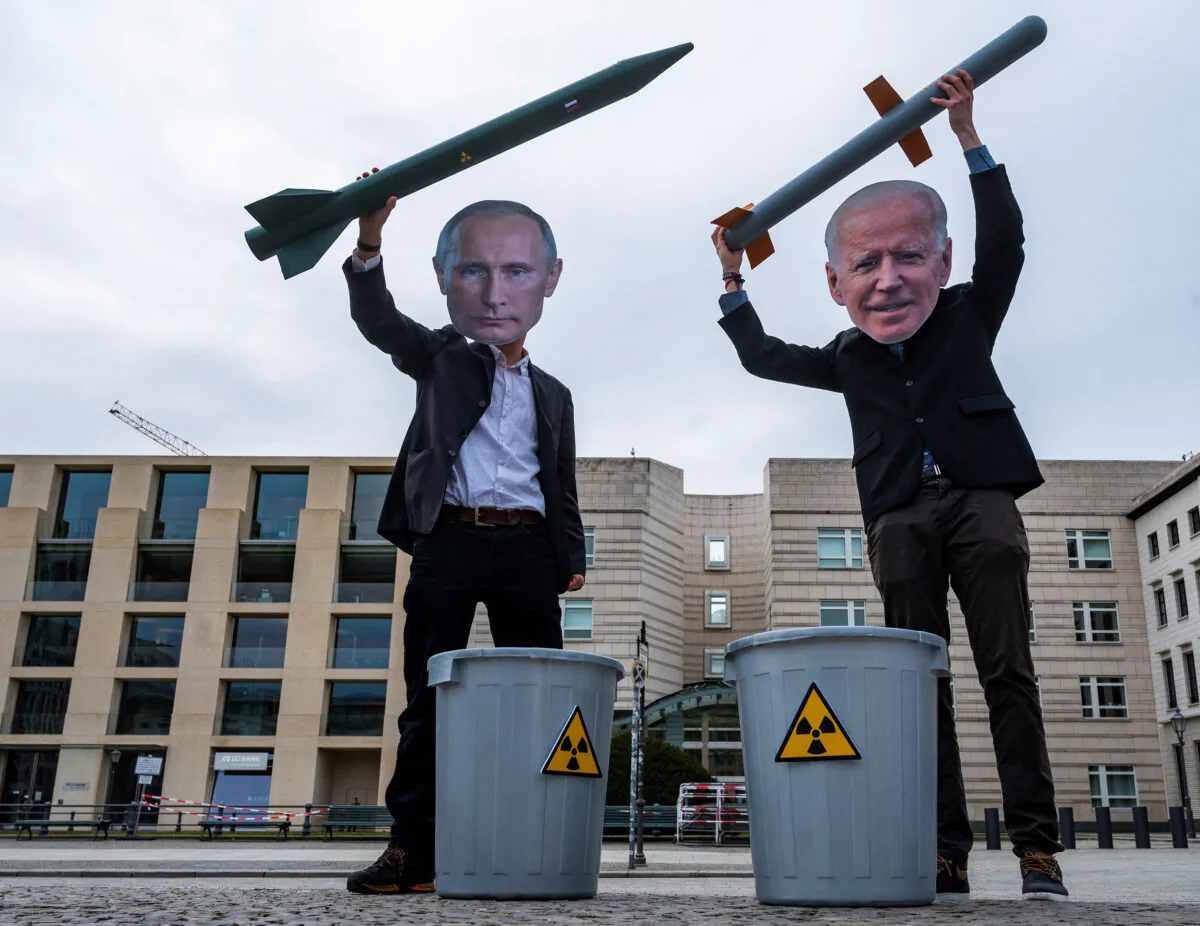 Peace activists wearing masks of Russian President Vladimir Putin (L) and newly elected U.S. President Joe Biden pose with mock nuclear missiles in front of the U.S. embassy in Berlin, Germany, on Jan. 29, 2021. (John Macdougall/AFP/Getty Images)