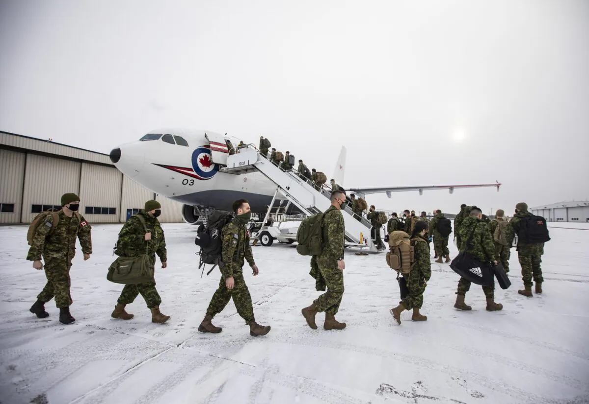 Eighty soldiers from across 3rd Canadian Division board a plane while deploying to Poland to join the lead elements already in that country as part of the Government of Canada's response to the war in Ukraine, in Edmonton, April 15, 2022. (The Canadian Press/Jason Franson)