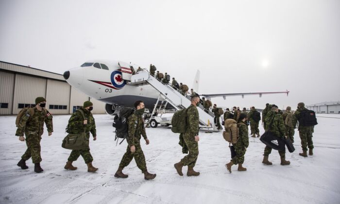Eighty soldiers from across 3rd Canadian Division board a plane while deploying to Poland to join the lead elements already in that country as part of the Government of Canada's response to the war in Ukraine, in Edmonton, April 15, 2022. (The Canadian Press/Jason Franson)