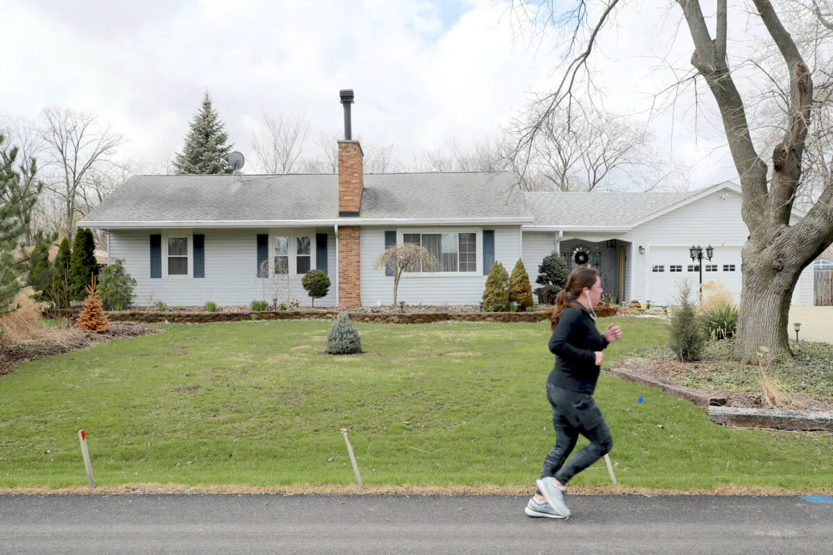 A jogger passes in front of the former home of Penny Parrish, on Wednesday, April 6, 2022, in Bensenville, Illinois. (Stacey Wescott/Chicago Tribune/TNS)