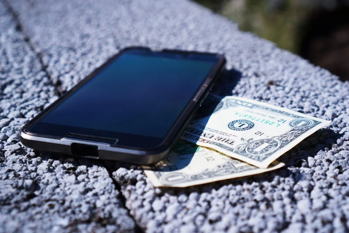 A smartphone next to dollar bills. (TheDigitalWay/Pixabay)