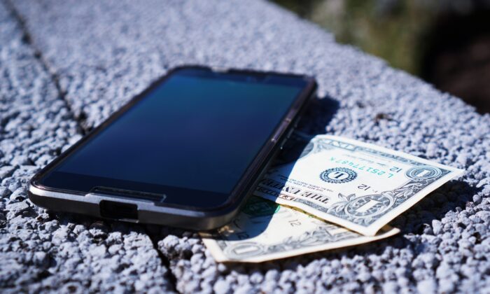 A smartphone next to dollar bills. (TheDigitalWay/Pixabay)