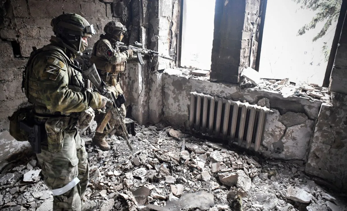 Two Russian soldiers patrol in the Mariupol drama theatre, which was bombed on March 16, in Mariupol, Ukraine, on April 12, 2022. (Alexander Nemenov/AFP via Getty Images)