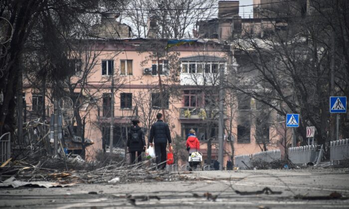 People look at a bombed-out building in central Mariupol, Ukraine, on April 12, 2022. (Alexander Nemenov/AFP via Getty Images)