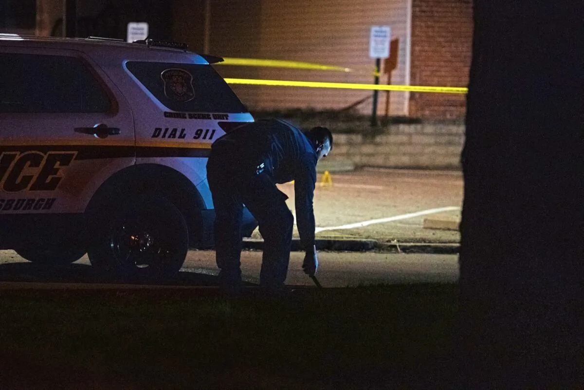 A police officer works on the scene on Pittsburgh's North Side after a shooting on April 17, 2022. (Shane Dunlap/Pittsburgh Tribune-Review via AP)