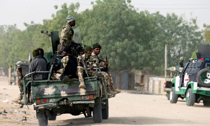 Nigerian military ride on their truck as they secure the area where a man was killed by suspected militants during an attack around Polo area of Maiduguri, Nigeria, on Feb. 16, 2019. (Afolabi Sotunde/Reuters)