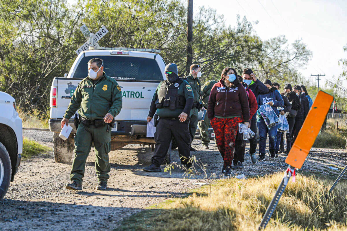 Border Patrol agents apprehend illegal immigrants after they cross the Rio Grande from Mexico into the United States, in La Joya, Texas, on Jan. 14, 2022. (Charlotte Cuthbertson/The Epoch Times)