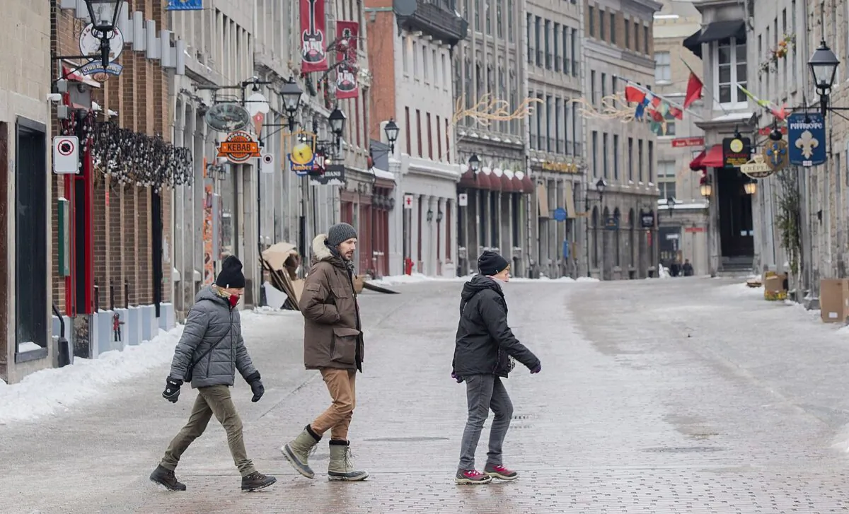 People cross a deserted street in Old Montreal on Feb. 8, 2022, during provincial restrictions to curb the spread of COVID-19. (The Canadian Press/Graham Hughes)
