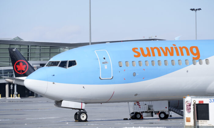 A Sunwing aircraft is parked at Montreal Trudeau airport in Montreal on March 2, 2022. (Paul Chiasson/The Canadian Press)