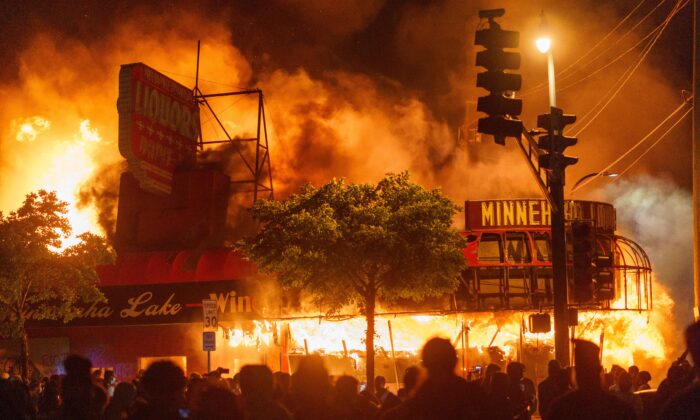 Protesters gather in front of a liquor store in flames near the Third Police Precinct in Minneapolis, Minnesota, on May 28, 2020. (Kerem Yucel/AFP via Getty Images)