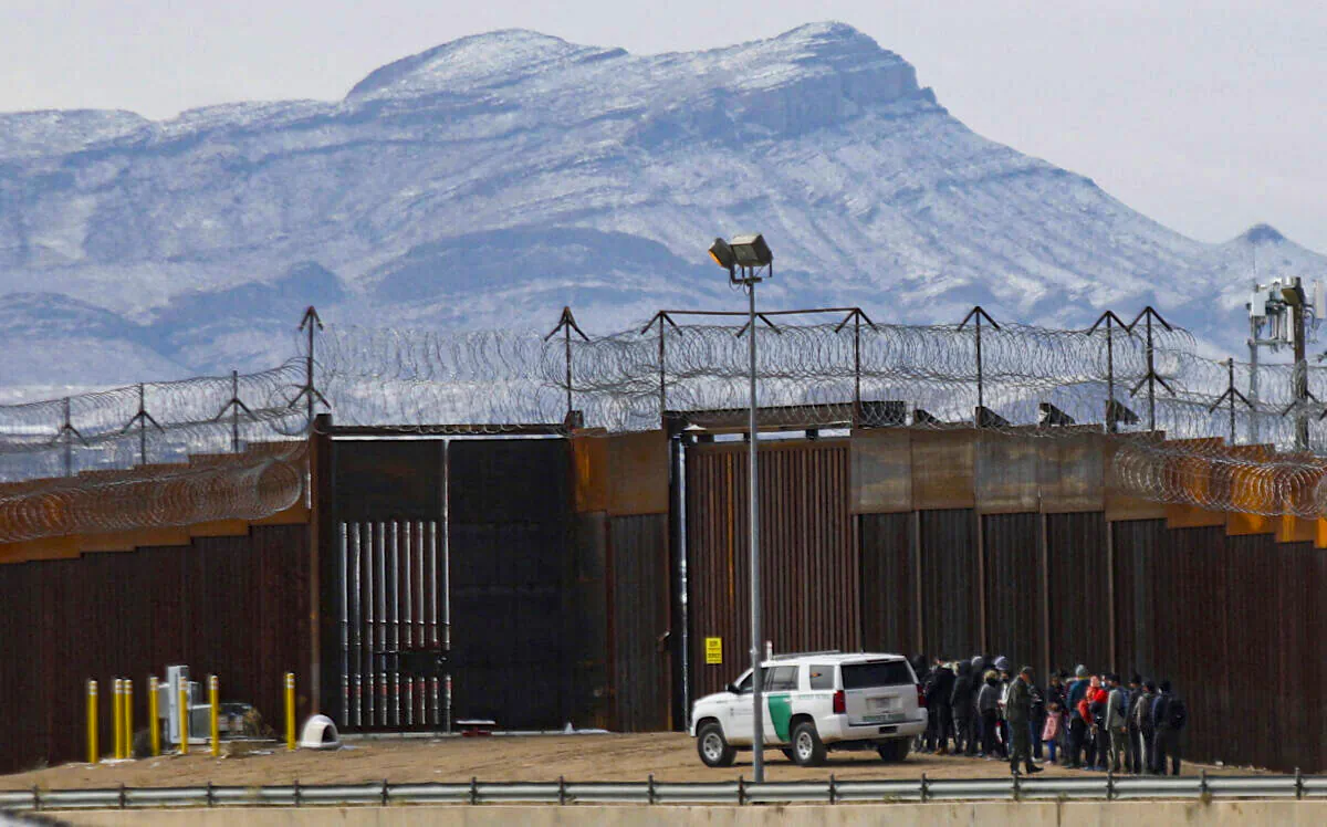 Border Patrol agents detain a group of migrants near the border wall after they entered the United States from Ciudad Juarez on Feb. 3, 2022. (Herika Martinez/AFP via Getty Images)