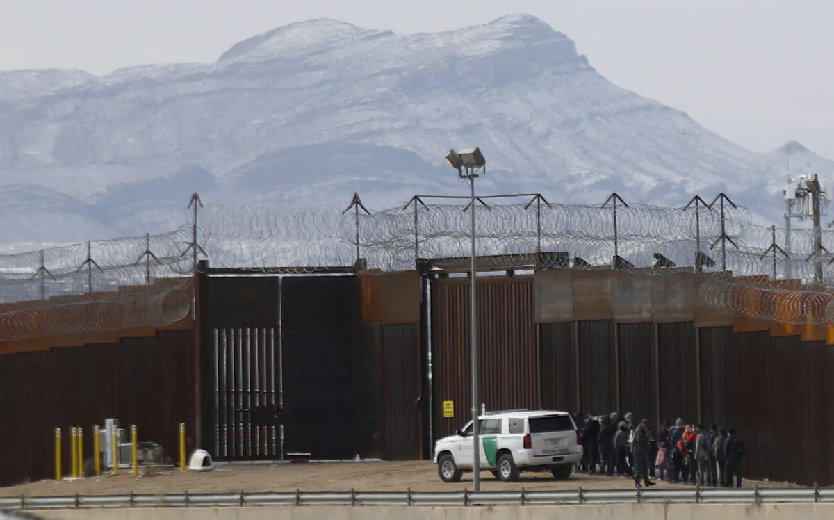 Border Patrol agents detain a group of migrants near the border wall after they entered the United States from Ciudad Juarez, Mexico, which shares a border with El Paso, Texas, on Feb. 3, 2022. (Herika Martinez/AFP via Getty Images)