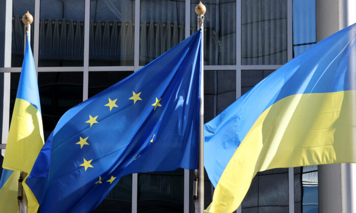 The Ukrainian flag flutters alongside the European Union flag outside the European Parliament headquarters to show their support for Ukraine after the nation was invaded on Feb. 24 by Russia, in Brussels, on Feb. 28, 2022. (François Walschaerts/AFP via Getty Images)