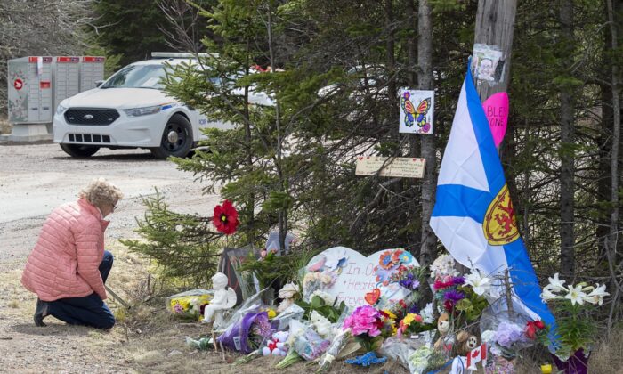 A woman pays her respects at a roadblock in Portapique, N.S., on April 22, 2020. (The Canadian Press/Andrew Vaughan)