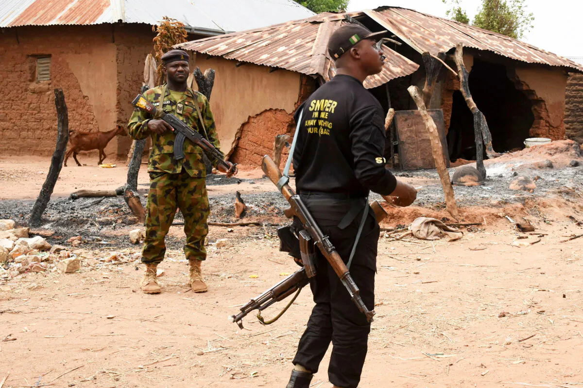 Security personnel stand guard in the Kukawa Village in the Kanam Local Government Area of the Plateau state on April 12, 2022, after resident's houses were burnt down during an attack by bandits. President Muhammadu Buhari vowed on April 12, 2022, there would be no mercy for those behind the killings of more than 100 people. (AFP via Getty Images)