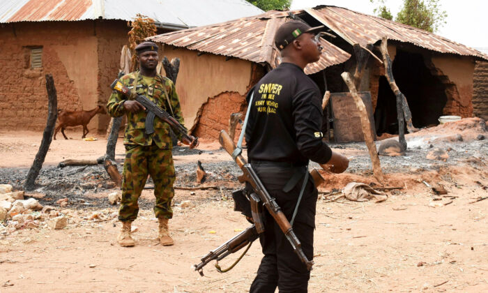 Security personnel stand guard in the Kukawa Village in the Kanam Local Government Area of the Plateau state on April 12, 2022, after resident's houses were burnt down during an attack by bandits. President Muhammadu Buhari vowed on April 12, 2022, there would be no mercy for those behind the killings of more than 100 people. (AFP via Getty Images)