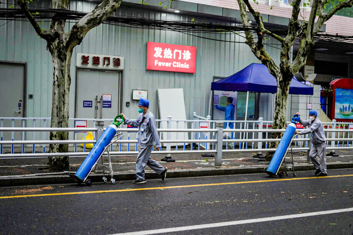 Workers deliver oxygen cylinders outside a hospital during lockdown in Shanghai, China April 14, 2022. (Aly Song/Reuters)