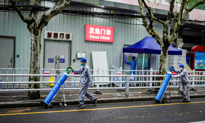 Workers deliver oxygen cylinders outside a hospital during lockdown in Shanghai, China April 14, 2022. (Aly Song/Reuters)