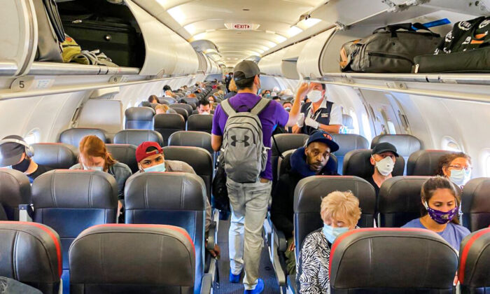 Passengers, almost all wearing masks, board an American Airlines flight to Charlotte, in New York City, on May 3, 2020. (Eleonore Sens/AFP via Getty Images)
