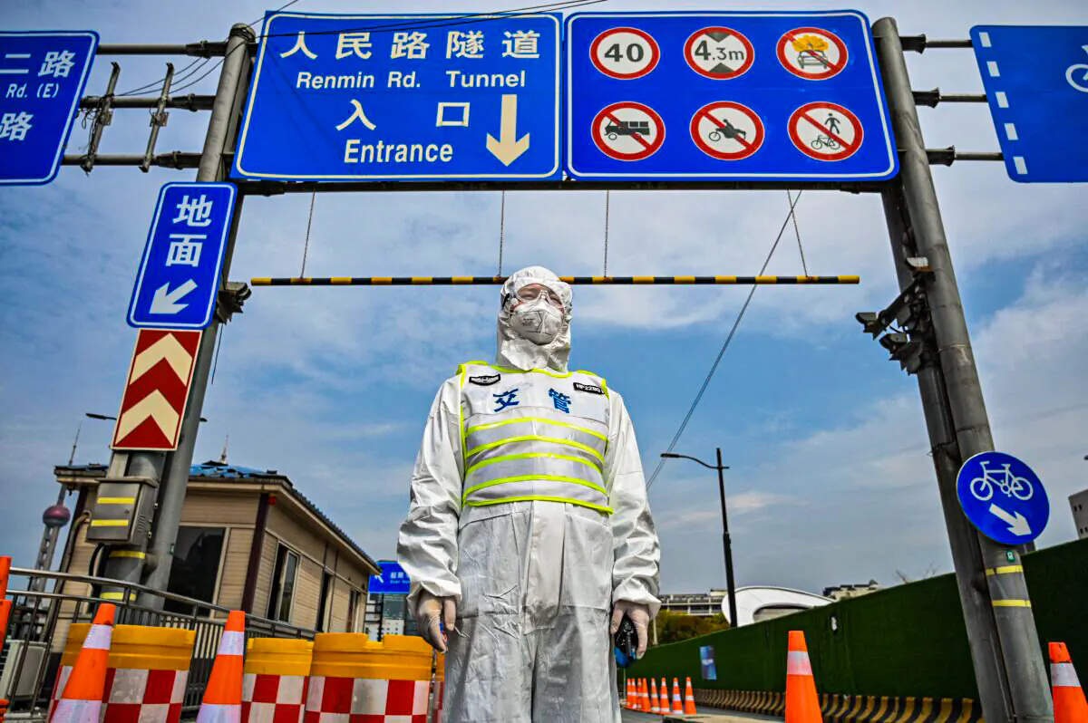 A transit officer, wearing a protective gear, controls access to a tunnel in the direction of Shanghai's Pudong district in lockdown on March 28, 2022.(Hector Retamal/AFP via Getty Images)